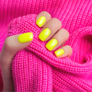 Painted yellow nails on hand clutching pink wool