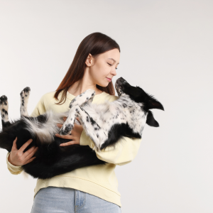 Female pet owner cradling their dog for a pet brand photoshoot